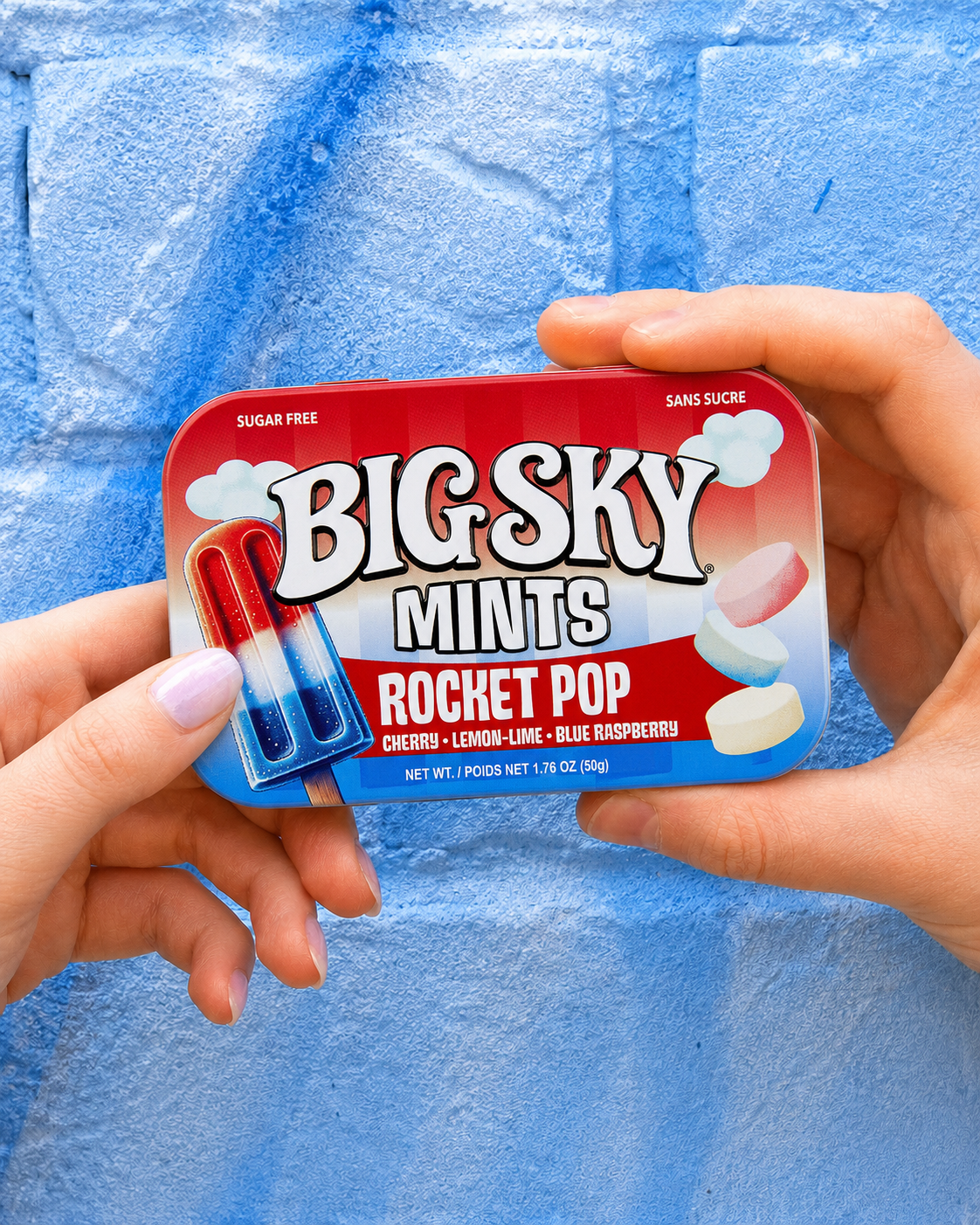 Hands holding Big Sky Mints Rocket Pop tin